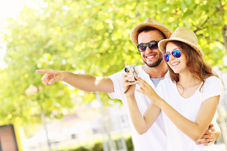 A picture of a happy couple taking pictures in the cityの写真素材