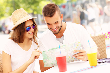 A picture of beautiful couple looking at map in a cafeの写真素材