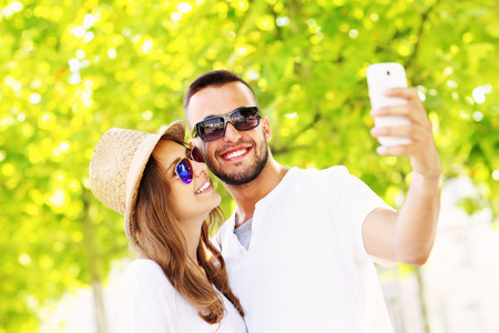 A picture of a young couple taking selfie in the parkの写真素材