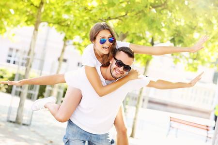 A picture of a joyful couple doing piggyback in the parkの写真素材
