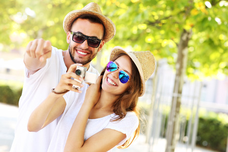 A picture of a happy couple taking pictures in the cityの写真素材