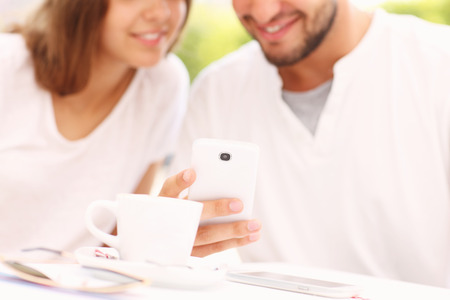 A picture of a blurry young couple and smartphoneの写真素材