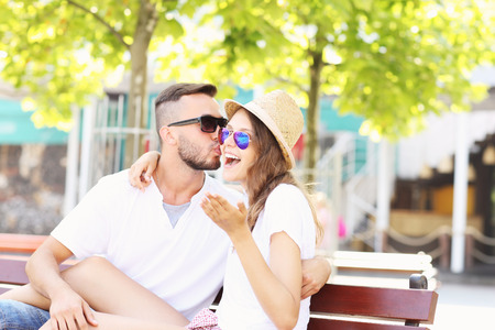 A picture of a joyful couple kissing on a benchの写真素材