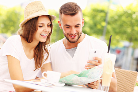 A picture of happy tourists with a map in a cafeの写真素材