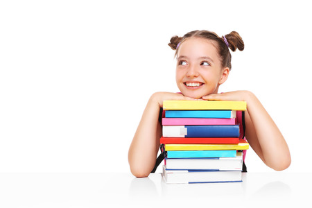 A picture of a young girls posing with a stack of books over white backgroundの写真素材