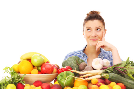 A picture of a happy woman with fruits and vegetables over white backgroundの写真素材