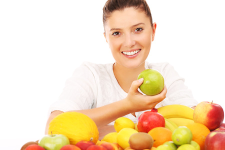 A picture of a happy woman with fruits over white backgroundの写真素材
