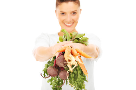 A picture of a happy woman with vegetables over white backgroundの写真素材