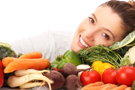 A picture of a happy woman with vegetables over white backgroundの写真素材