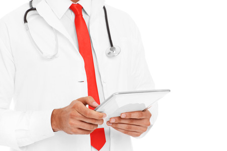 A midsection of a doctor holding tablet over white backgroundの写真素材