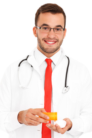 A midsection of a doctor holding pills over white backgroundの写真素材