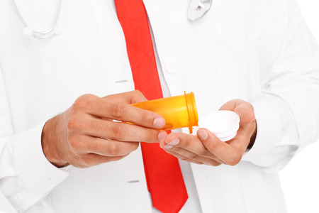 A midsection of a doctor holding pillsの写真素材