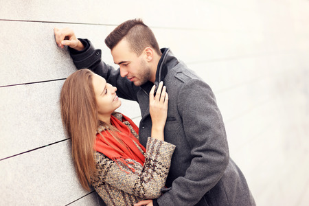 A picture of a romantic couple on an autumn date leaning against the wallの写真素材