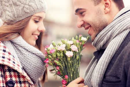 A picture of a man giving flowers to his lover on a winter day