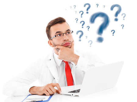 A picture of an unhappy doctor with laptop and documents sitting in the officeの写真素材