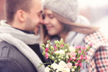 A picture of flowers and kissing couple in the backgroundの写真素材