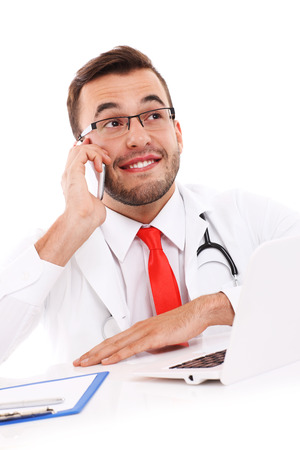 A picture of a happy doctor talking on the phone in the officeの写真素材