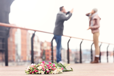 A picture of lost flowers and a couple arguing in the backgroundの写真素材