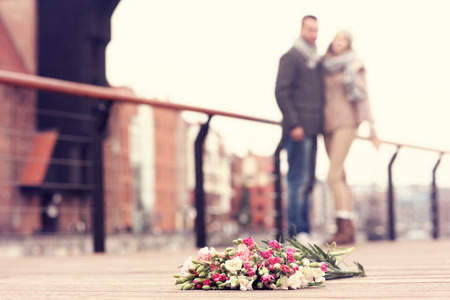 A picture of flowers and hugging couple in the backgroundの写真素材
