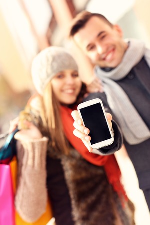 A picture of a couple showing smartphone while shoppingの写真素材