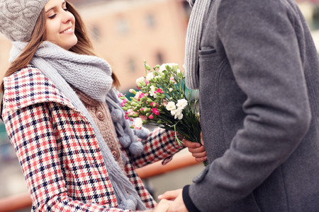 A picture of a romantic couple on a date holding flowersの写真素材