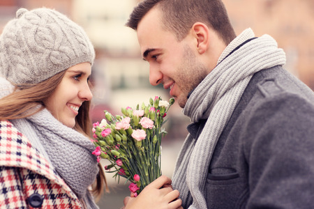 A picture of a romantic couple on a date holding flowersの写真素材