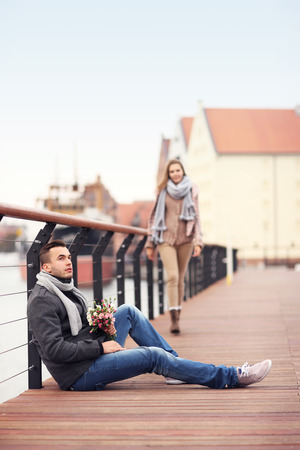 A picture of a young man waiting for a woman with flowersの写真素材