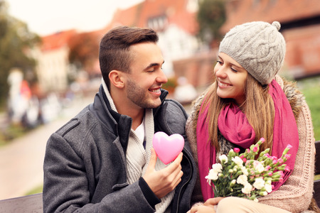 A picture of a couple on Valentine's Day in the park with flowers and heartの写真素材