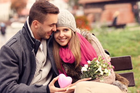 A picture of a couple on Valentine's Day in the park with flowers and heartの写真素材