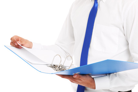 A midsection of a businessman holding documents over white backgroundの写真素材