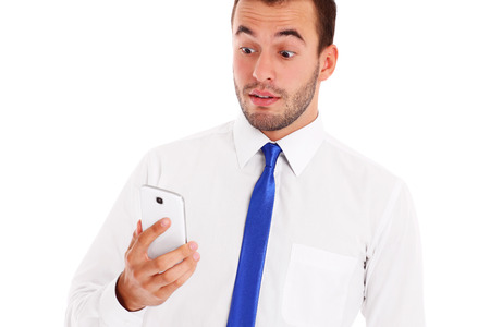 A picture of a shocked businessman checking his smartphone over white backgroundの写真素材