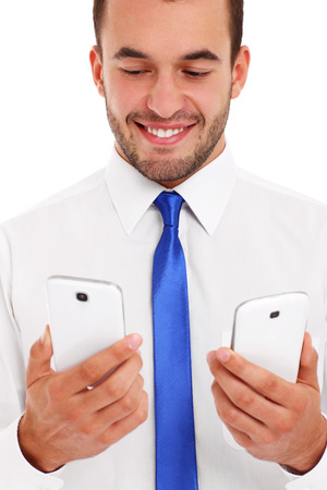 A picture of a businessman with two smartphones over white backgroundの写真素材
