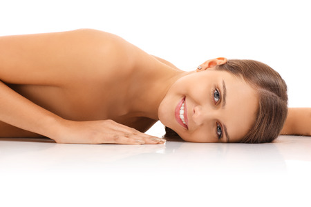 A picture of a pretty sensual nude woman lying over white backgroundの写真素材