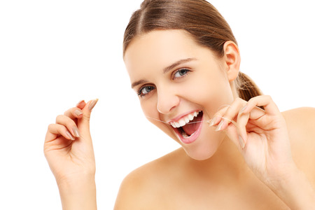 A picture of a young woman using dental floss over white backgroundの写真素材