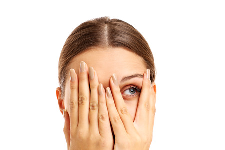 A picture of a terrified woman covering her face over white backgroundの写真素材