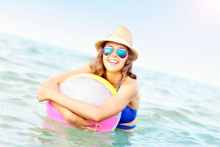 A picture of a young woman playing with a ball in the seaの写真素材