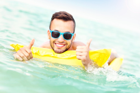 A picture of a young man swimming on a matress in the Baltic Sea