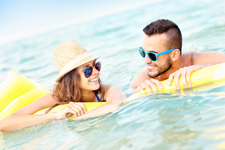 A picture of a young couple having fun on a matress in the seaの写真素材