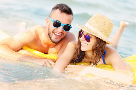 A picture of a young couple swimming on a matress in the seaの写真素材