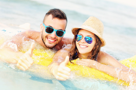 A picture of a young couple swimming on a matress in the seaの写真素材