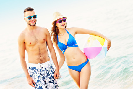 A picture of a young couple walking along the beachの写真素材