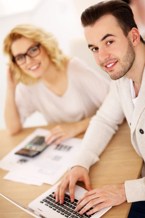 A picture of a young couple working on documents at homeの写真素材