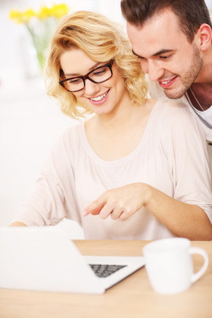 A picture of a happy couple using laptop at homeの写真素材