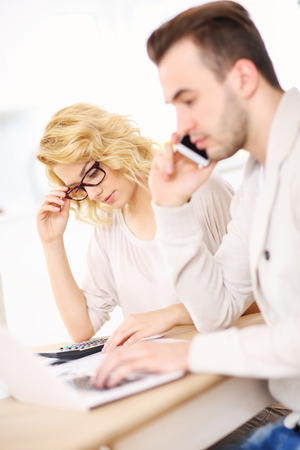 A picture of a worried couple with documents at homeの写真素材