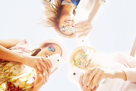A picture of group of friends using smartphones in the cityの写真素材