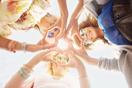 A picture of group of happy friends showing hearts