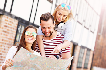 A picture of a group of happy friends sightseeing Gdansk with mapの写真素材