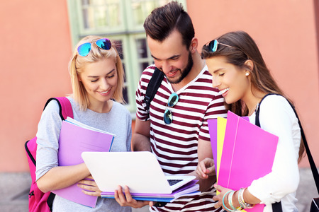 A picture of a group of happy students studying outdoorsの写真素材