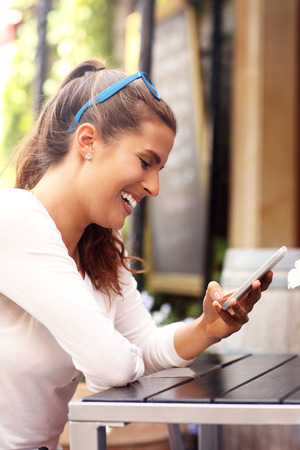 A picture of a happy woman using smartphone in cafeの写真素材