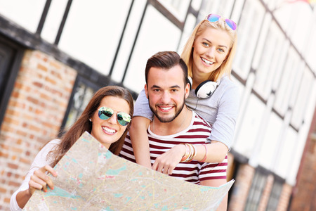 A picture of a group of happy friends sightseeing Gdansk with mapの写真素材